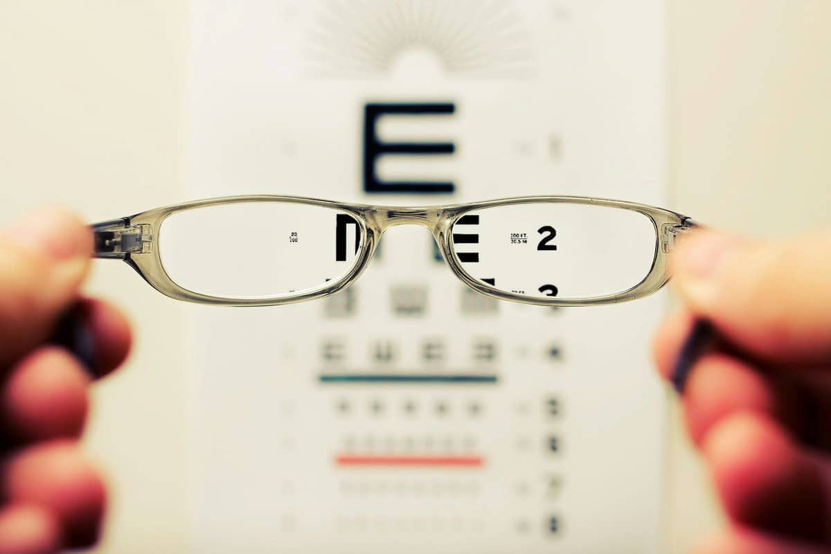 Optician performing a home eye test for an elderly woman in her living room