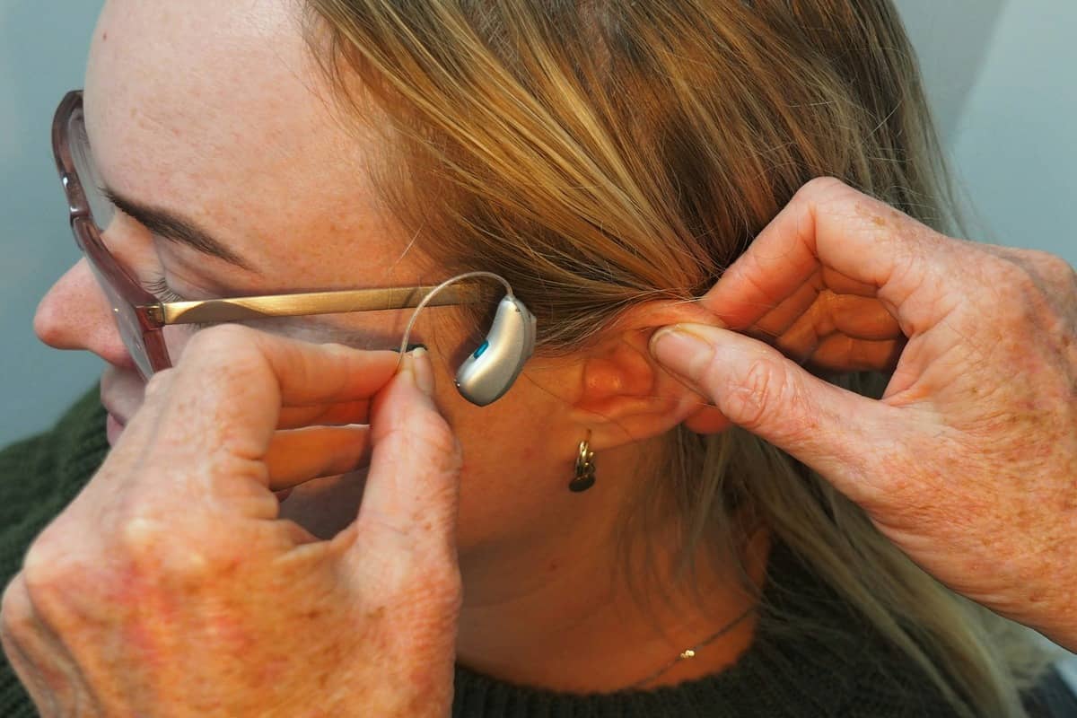 HomeSight audiologist carrying out a home hearing test with an older man in his living room